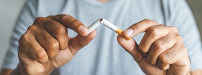 Closeup of man breaking cigarette