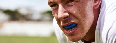 Closeup of man wearing blue mouthguard