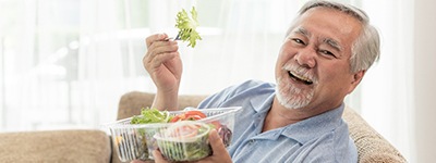 Patient in Chaska smiling as they eat