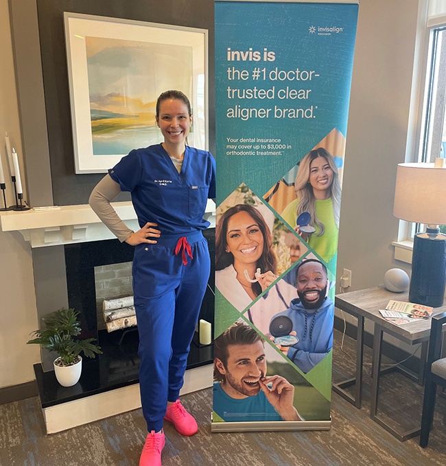 Dr. April Korte standing next to Invisalign sign 