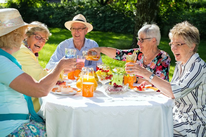 Elderly folks eating around a picnic table